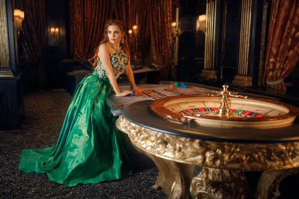 A woman in a luxurious green gown next to an ornate roulette wheel, capturing the upscale casino mood of KKFBB.